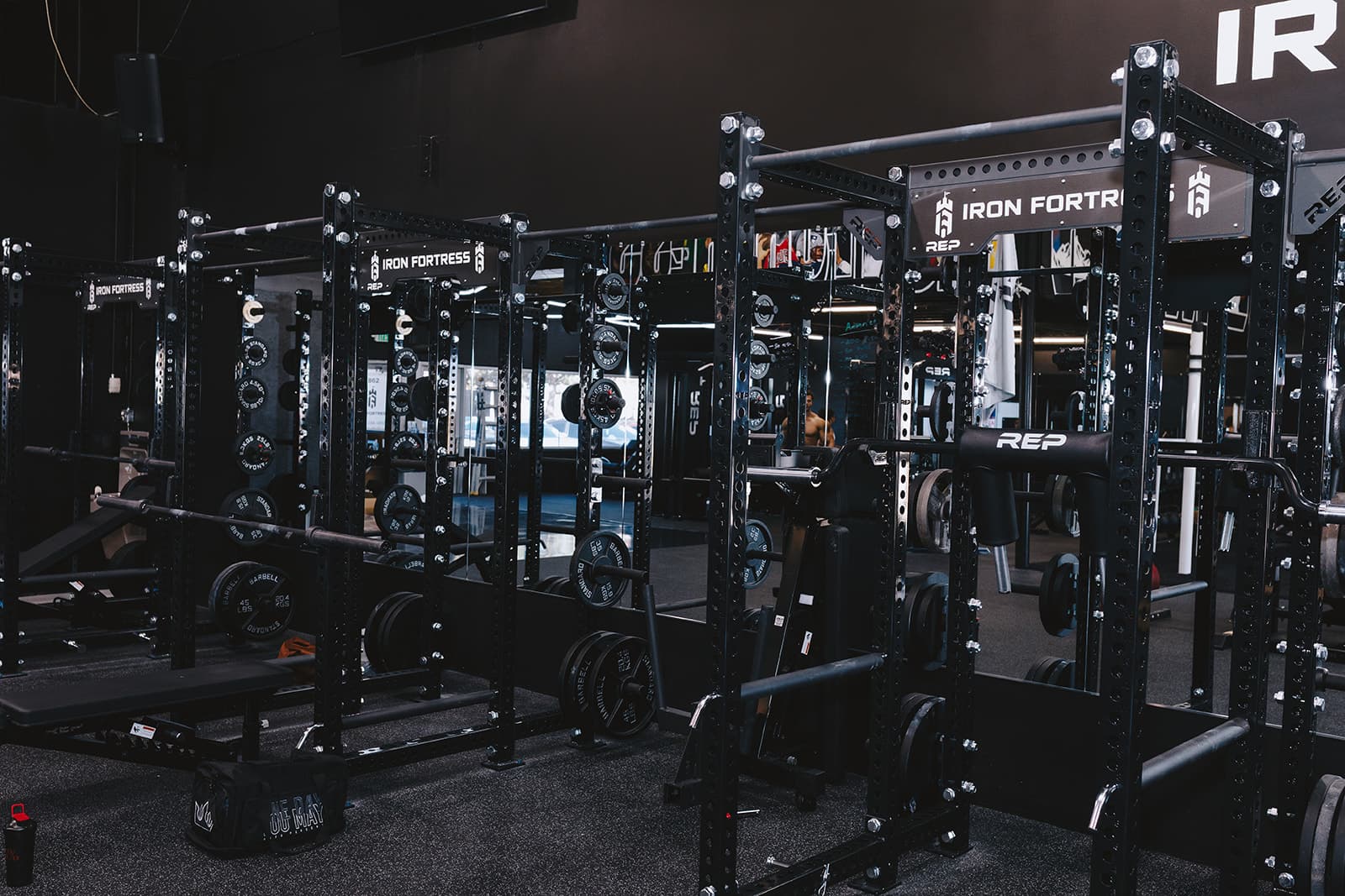 Iron Fortress warehouse gym floor with multiple power racks and lifting stations, Denver CO